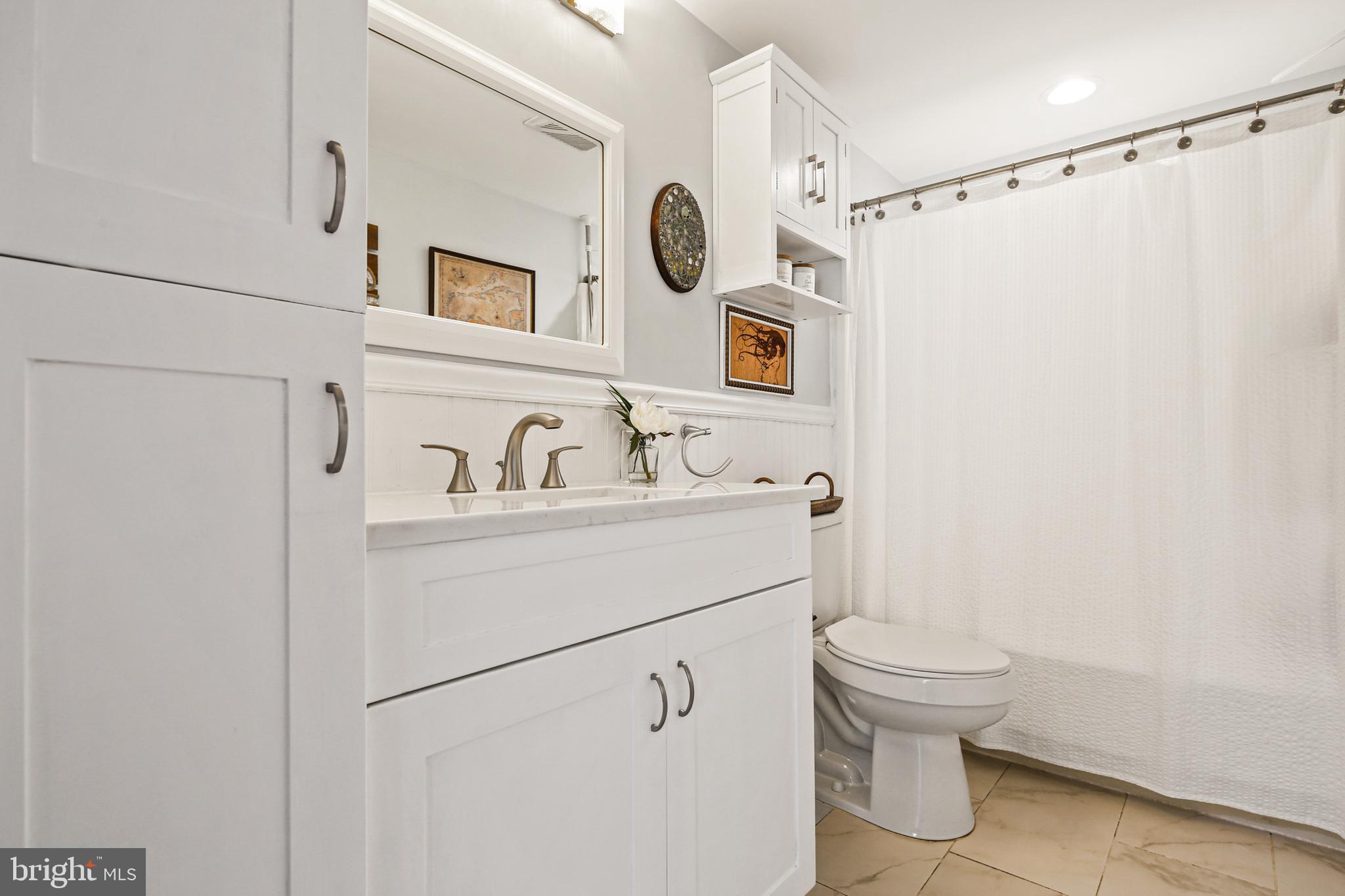 9348 Northgate Road Laurel, MD 20723 - Photo 17 of 42 a bathroom with a sink a toilet and shower curtain