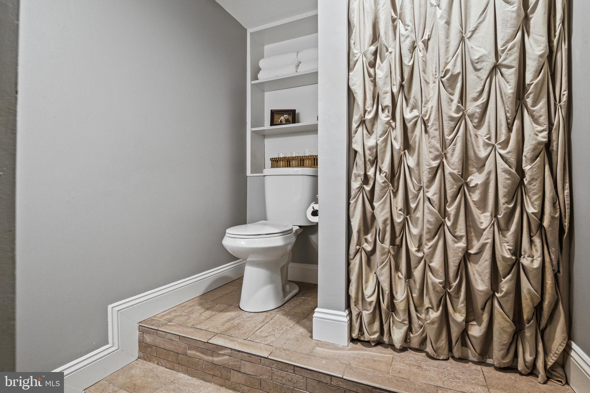 9348 Northgate Road Laurel, MD 20723 - Photo 31 of 42 a white toilet sitting next to a shower curtain