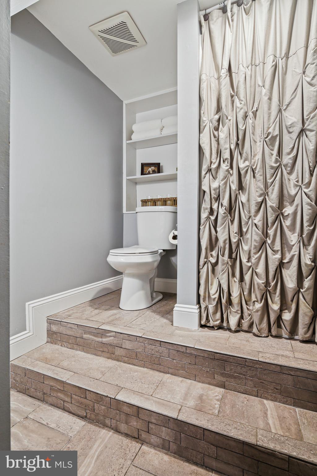 9348 Northgate Road Laurel, MD 20723 - Photo 32 of 42 a bathroom with a toilet and a shower curtain