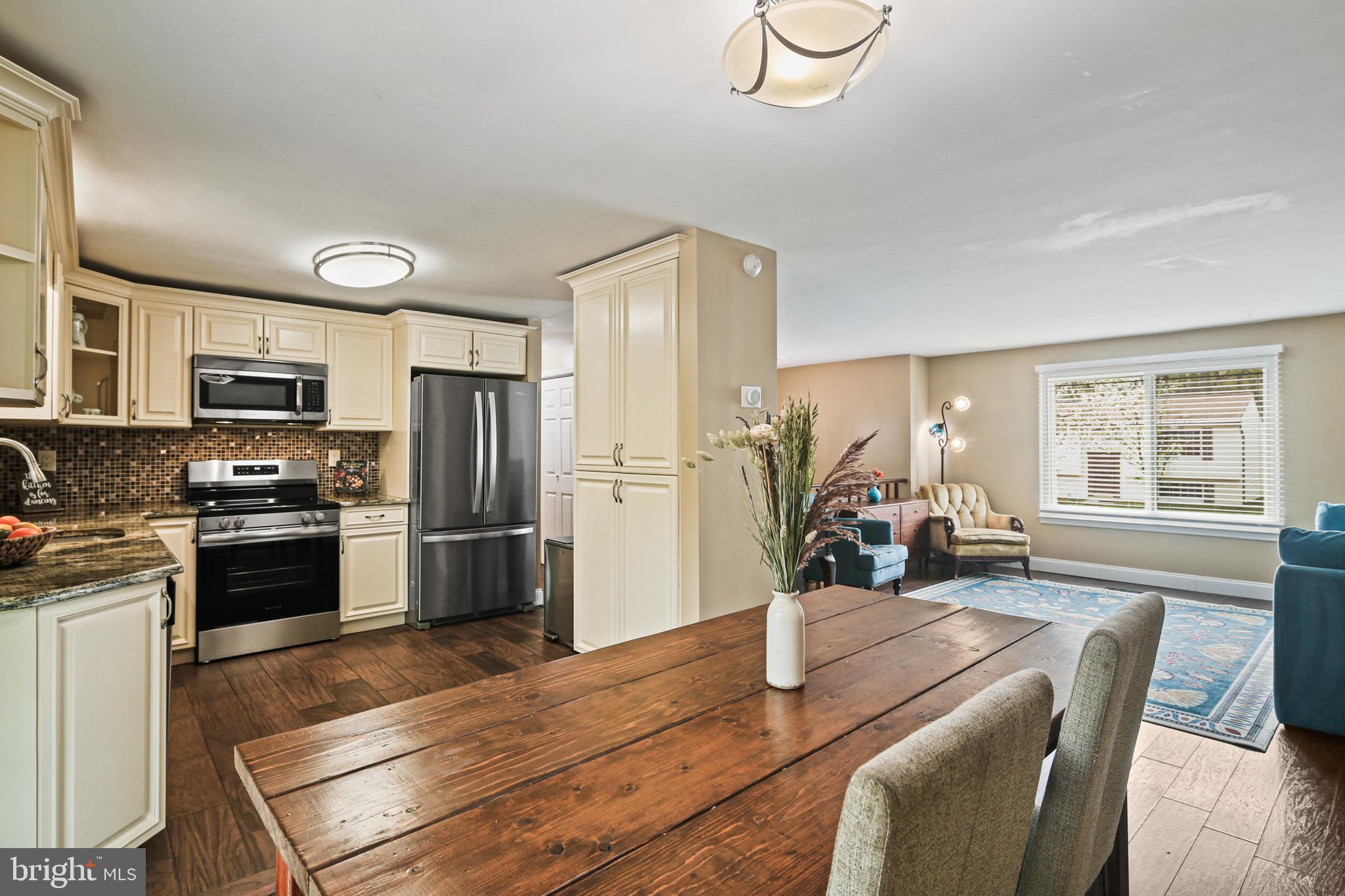 9348 Northgate Road Laurel, MD 20723 - Photo 4 of 42 a kitchen with stainless steel appliances granite countertop a refrigerator stove top oven dining table and chairs
