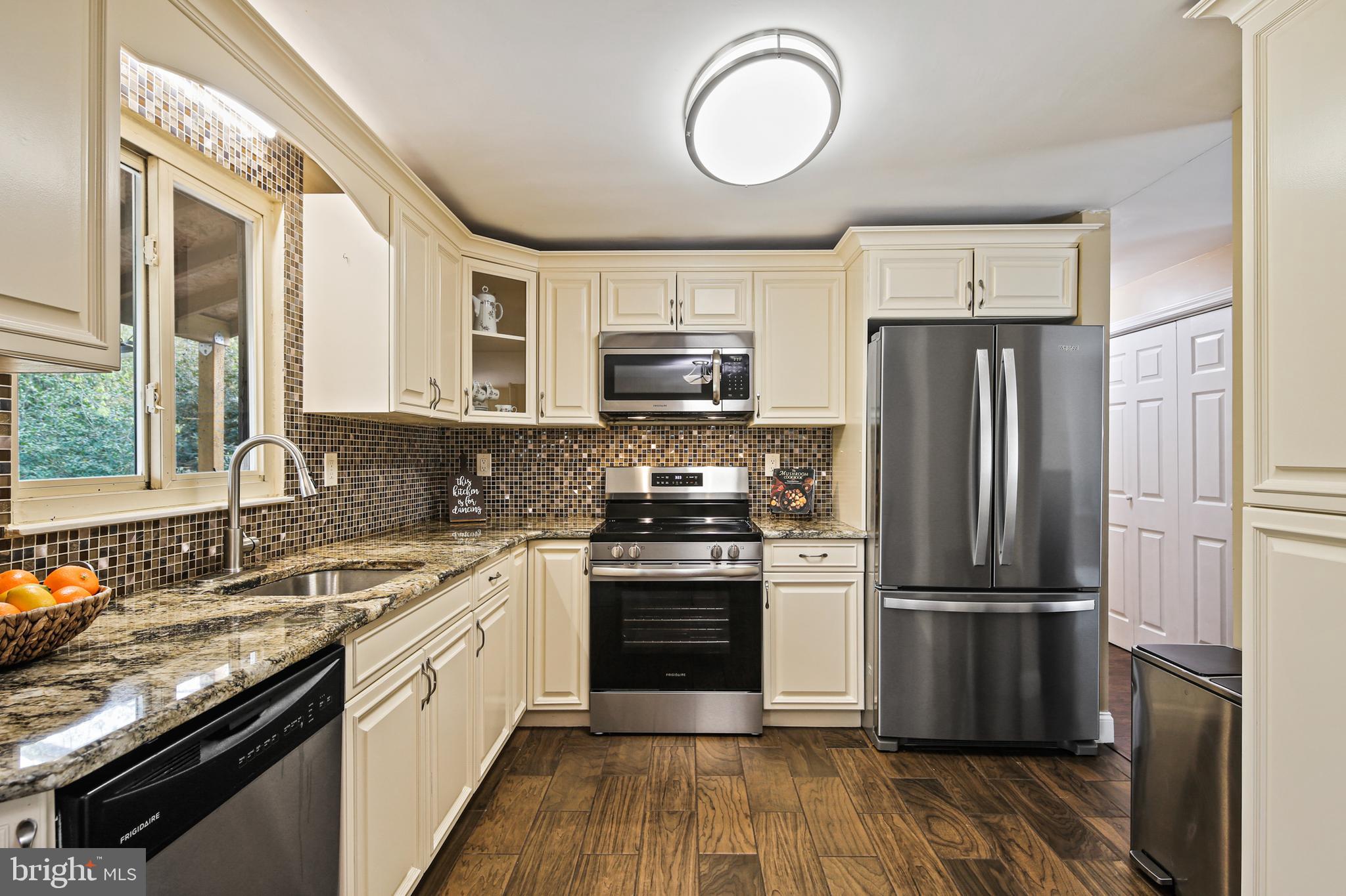 9348 Northgate Road Laurel, MD 20723 - Photo 5 of 42 a kitchen with a refrigerator sink and wooden floor