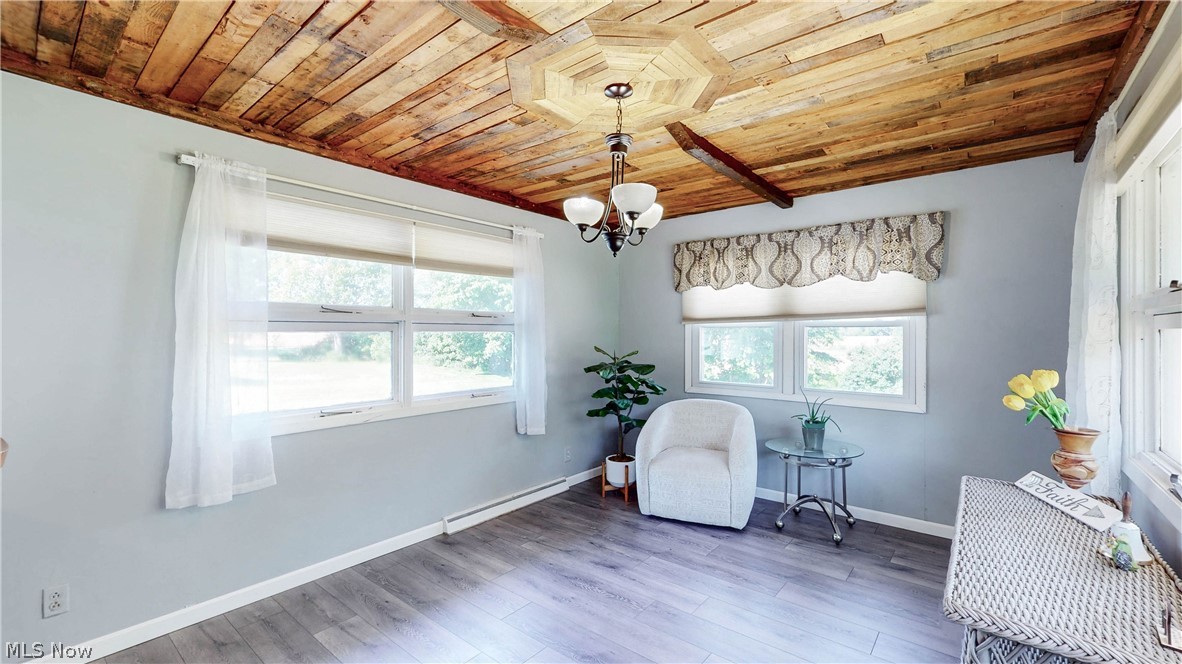 3659 Morrow Road Kent, OH 44240 - Photo 17 of 39 Vaulted wood plank ceiling with exposed beam, recessed chandelier lighting, light blue wall paint, multiple windows with natural light, and wood-finish flooring