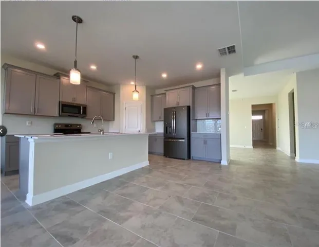 a view of a kitchen with a sink and a refrigerator