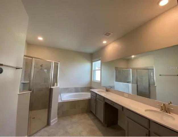 a large bathroom with a double vanity sink and mirror