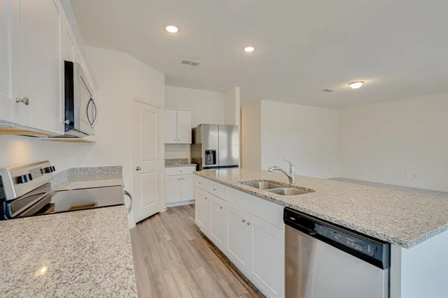 a kitchen with granite countertop cabinets a sink and a stove