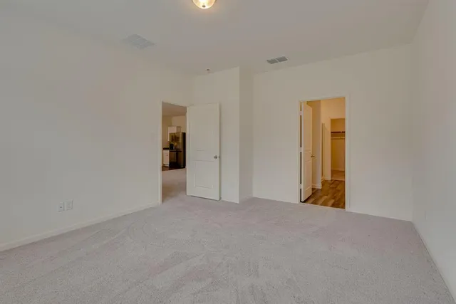 an empty room with a window and ceiling fan