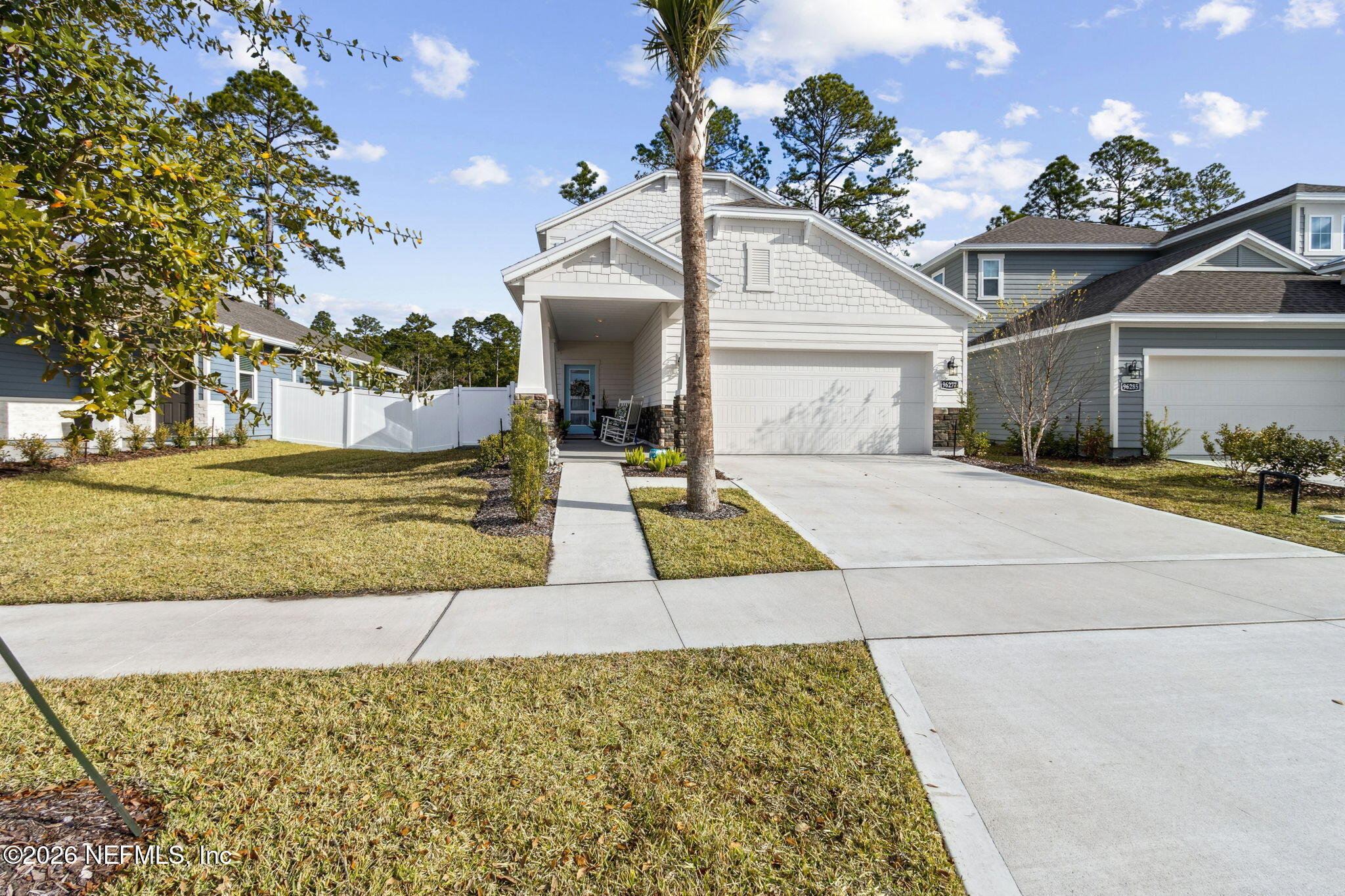 96277 Broadmoore Road Fernandina Beach, FL 32034 - Photo 1 of 31 a view of a white house with a yard and potted plants