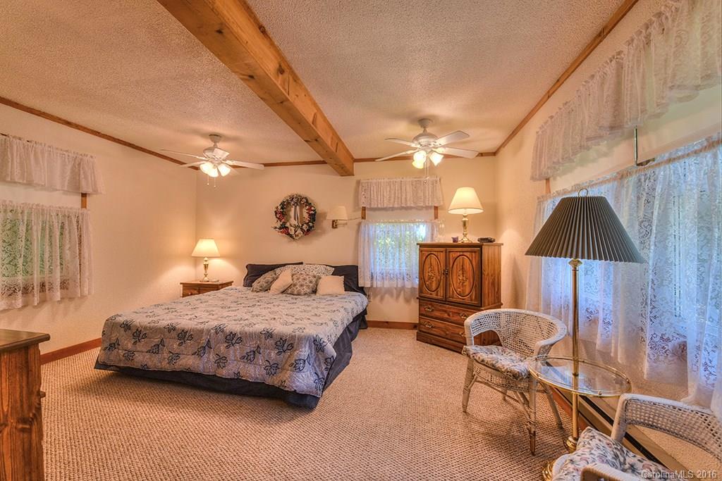 85 Miner Road Waynesville, NC 28785 - Photo 15 of 24 a bedroom with a bed a lamp and a closet