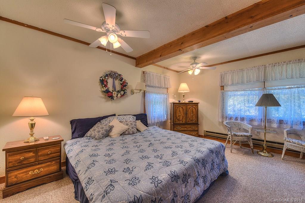 85 Miner Road Waynesville, NC 28785 - Photo 16 of 24 a bedroom with a bed and a chandelier