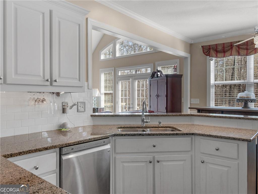 355 Parker Road Covington, GA 30014 - Photo 24 of 60 a kitchen with granite countertop a sink stainless steel appliances white cabinets and a window