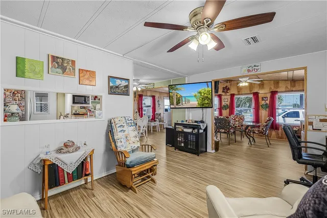 a kitchen with stainless steel appliances granite countertop a refrigerator a stove and a sink with wooden floor