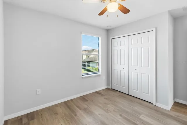 an empty room with window and ceiling fan