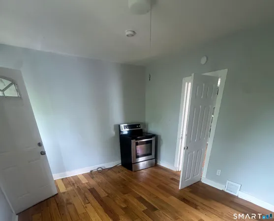 a view of a kitchen with refrigerator and wooden floor