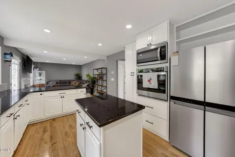 a kitchen with granite countertop a refrigerator stove top oven and sink