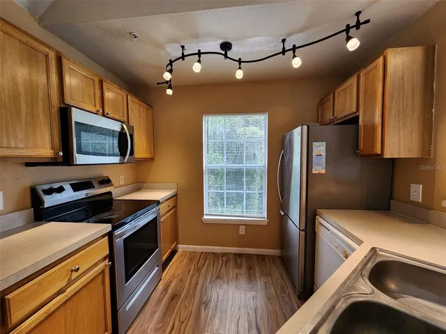 a kitchen that has a microwave a stove and a refrigerator