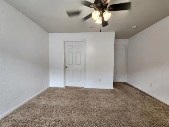 an empty room with chandelier fan