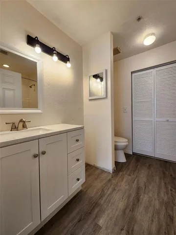 a spacious bathroom with a double vanity sink a mirror and toilet