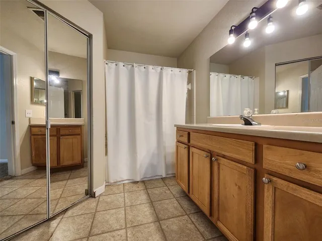 a bathroom with a double vanity sink a mirror and a shower