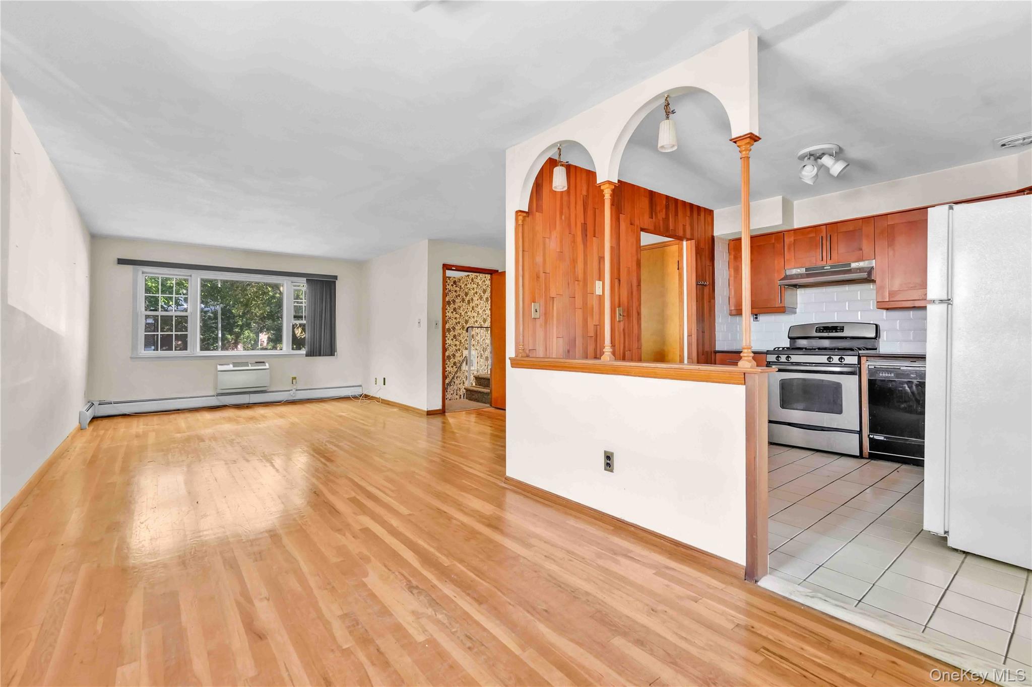 21260 16th Avenue Queens, NY 11360 - Photo 12 of 37 a kitchen with stainless steel appliances a stove top oven a sink dishwasher and a refrigerator with wooden floor
