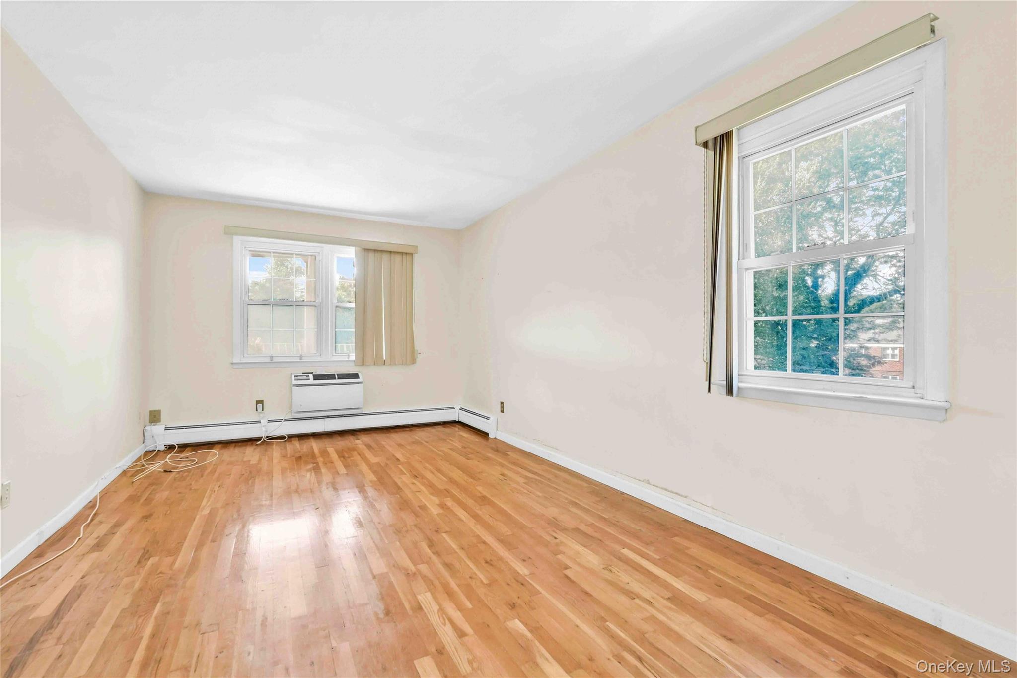 21260 16th Avenue Queens, NY 11360 - Photo 16 of 37 an empty room with wooden floor and windows