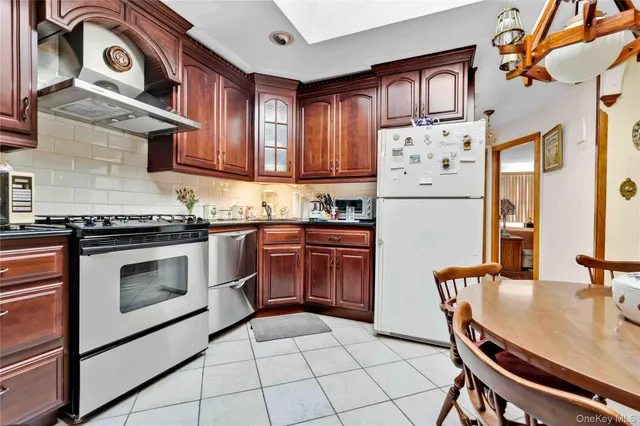 a kitchen with granite countertop a stove top oven cabinets and a refrigerator