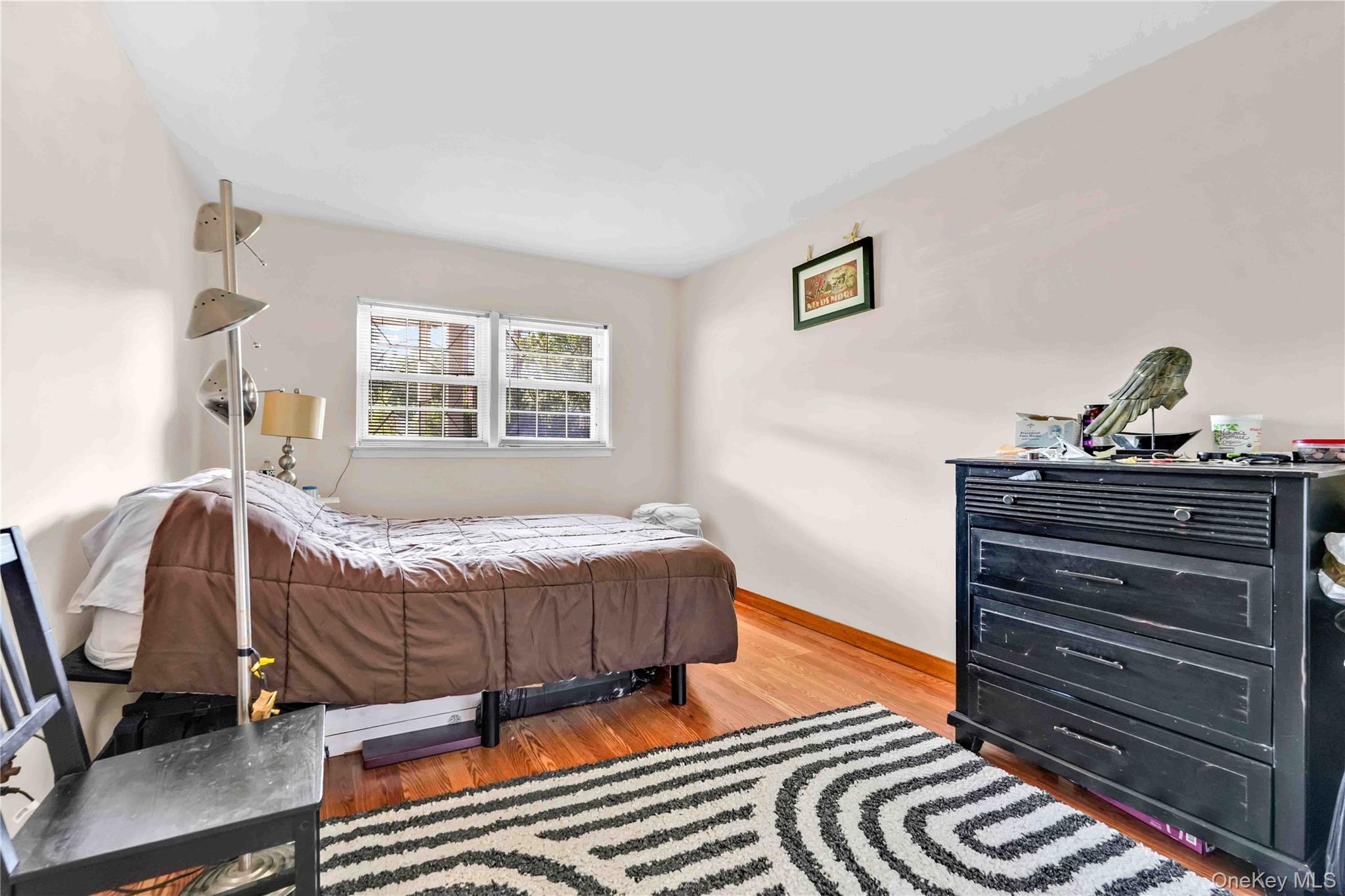 21260 16th Avenue Queens, NY 11360 - Photo 27 of 37 a bedroom with a bed and wooden floor