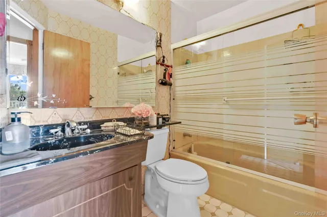 a bathroom with a granite countertop sink a toilet and shower