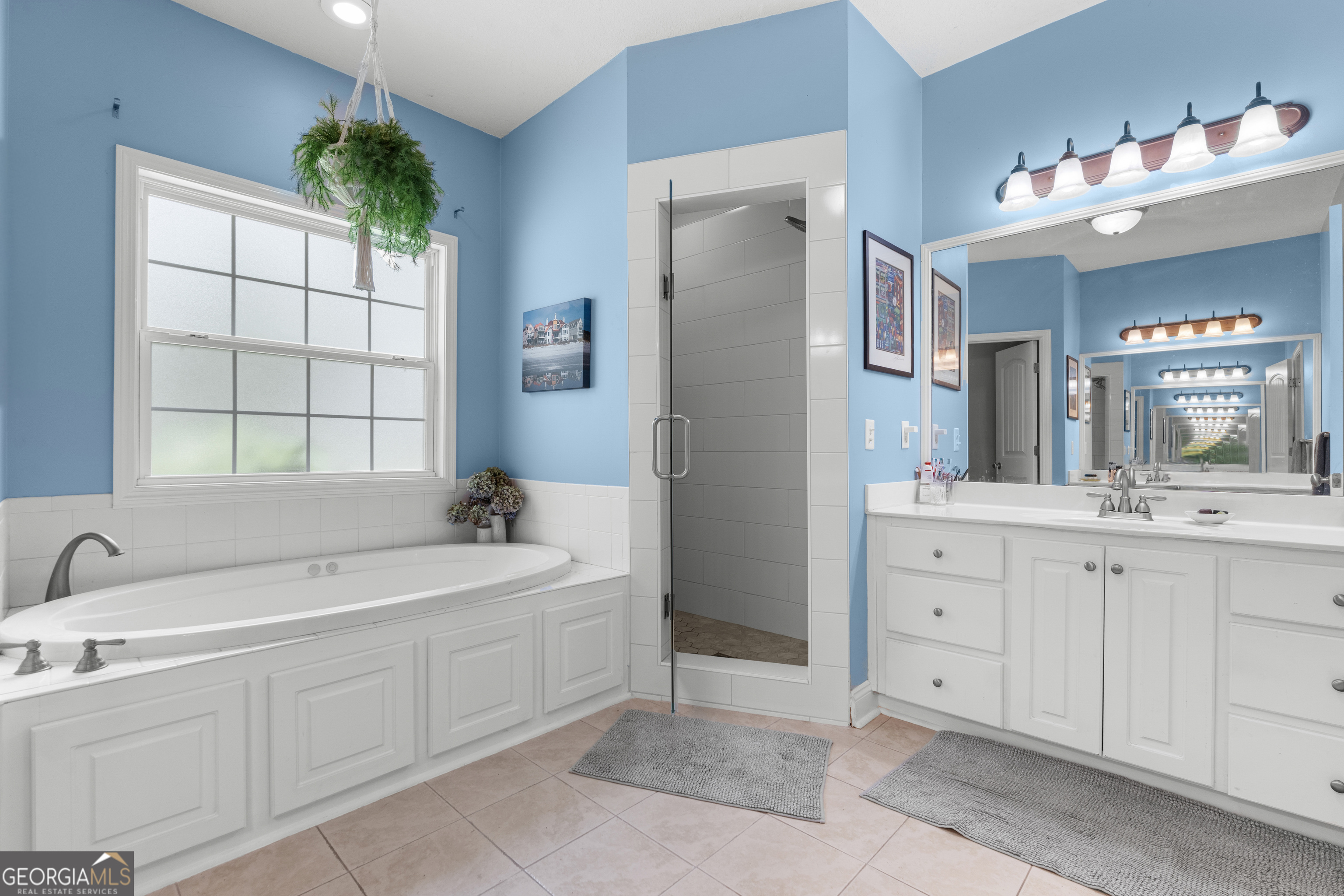 1603 Lennox Road Statesboro, GA 30461 - Photo 22 of 45 a spacious en suite bathroom with a double vanity sink a large mirror and a bathtub next to a window