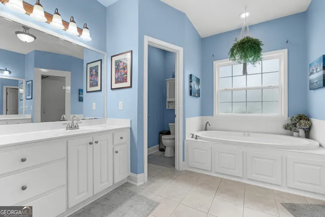 a bathroom with a tub sink and mirror