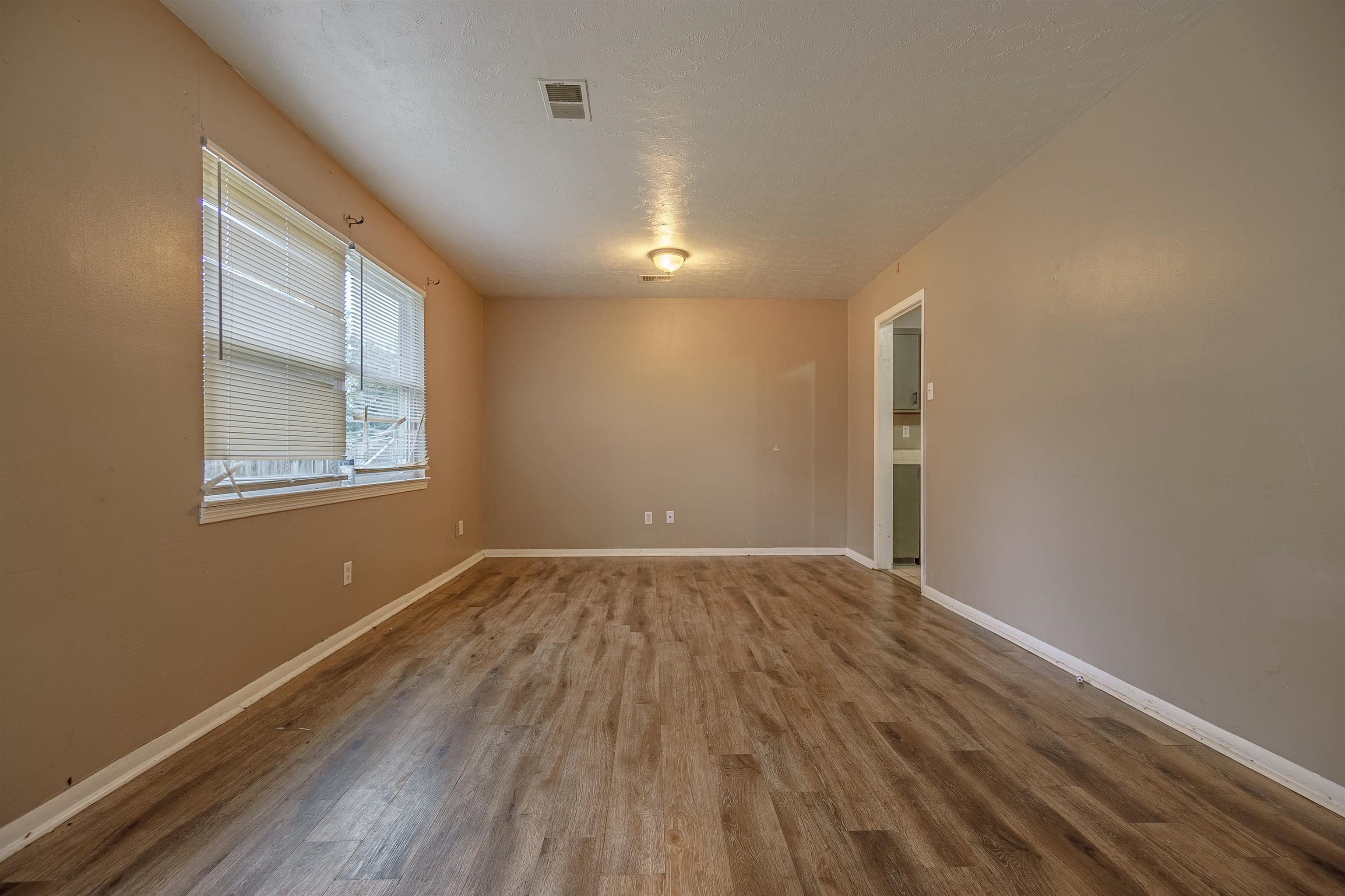 3065 Randy Lane Memphis, TN 38118 - Photo 9 of 16 a view of an empty room with wooden floor and a window