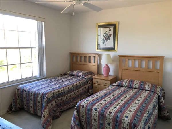 a bedroom with two beds and a window