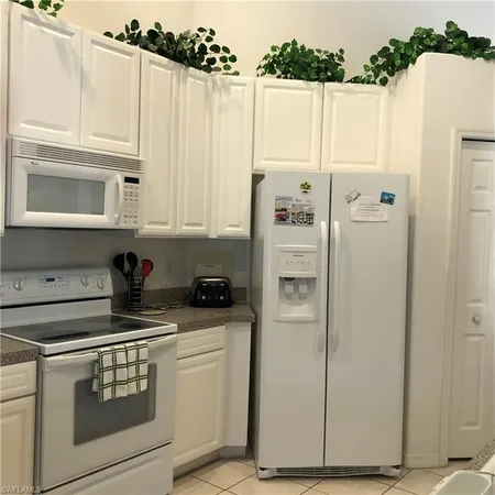 a kitchen with a refrigerator stove and white cabinets