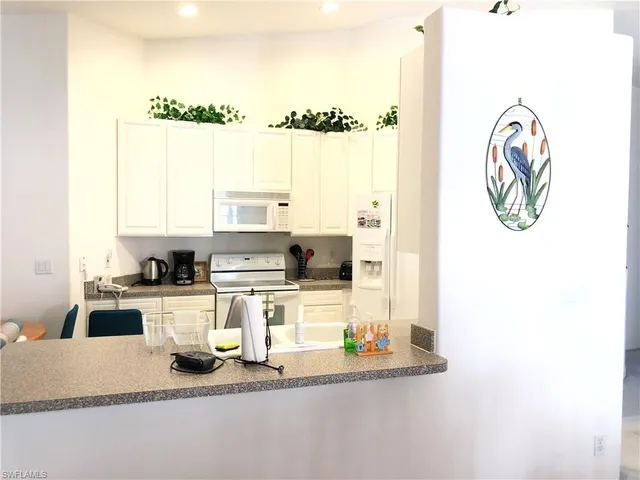 a kitchen with a refrigerator and a stove top oven