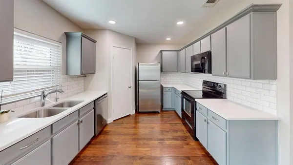 a large kitchen with stainless steel appliances sink a microwave and cabinets
