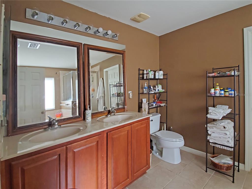 10025 Winding River Road Punta Gorda, FL 33950 - Photo 19 of 30 a spacious bathroom with a double vanity sink a toilet and a mirror