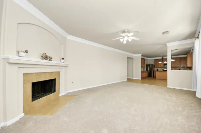 a view of a livingroom with a fireplace and a chandelier fan
