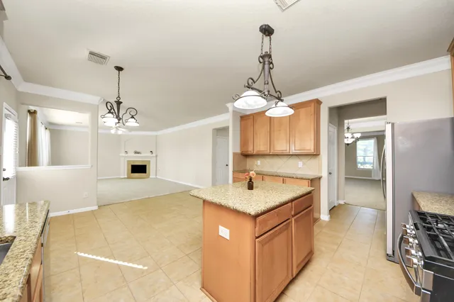 a hall with kitchen island a sink wooden floor and a chandelier