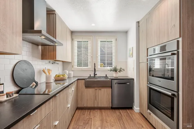 a kitchen with stainless steel appliances granite countertop a sink stove and refrigerator
