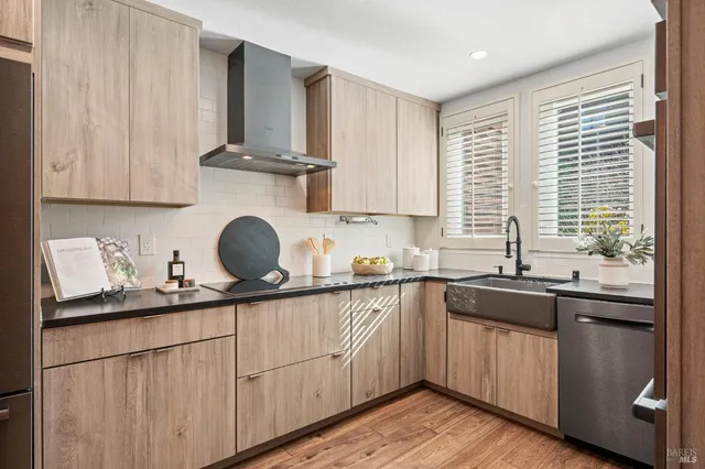 a kitchen with stainless steel appliances granite countertop a sink and cabinets with wooden floor