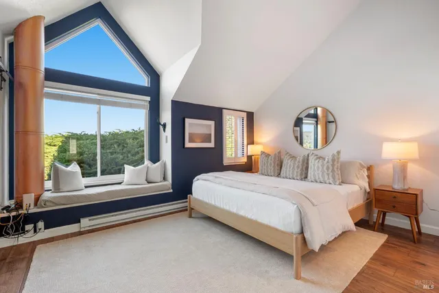 a bedroom with a bed and a large window with outer view