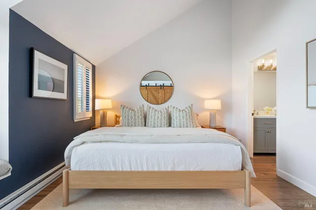 a bedroom with a bed mirror and window