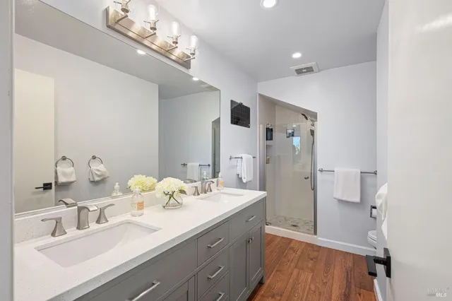 a bathroom with a sink double vanity granite and shower
