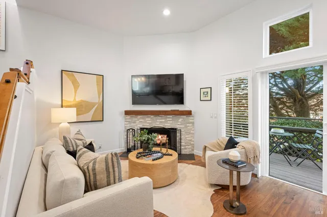 a living room with furniture floor to ceiling window and a fireplace