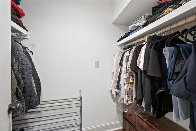 a view of walk in closet with clothes and shoes