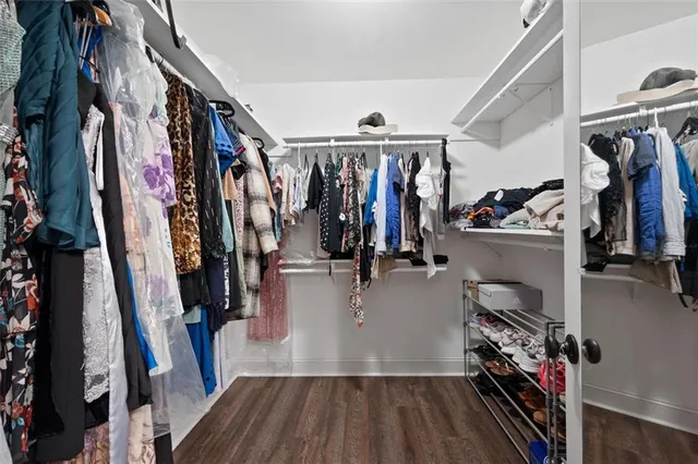 a view of walk in closet with clothes and shoes