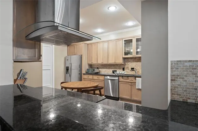 a kitchen with stainless steel appliances granite countertop a sink a stove and a refrigerator