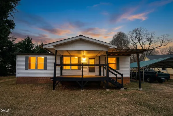 a view of a house with a backyard and a tree