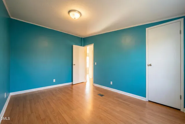 an empty room with wooden floor and entrance
