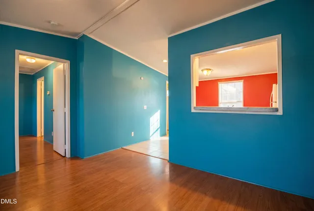 a view of empty room with window and wooden floor