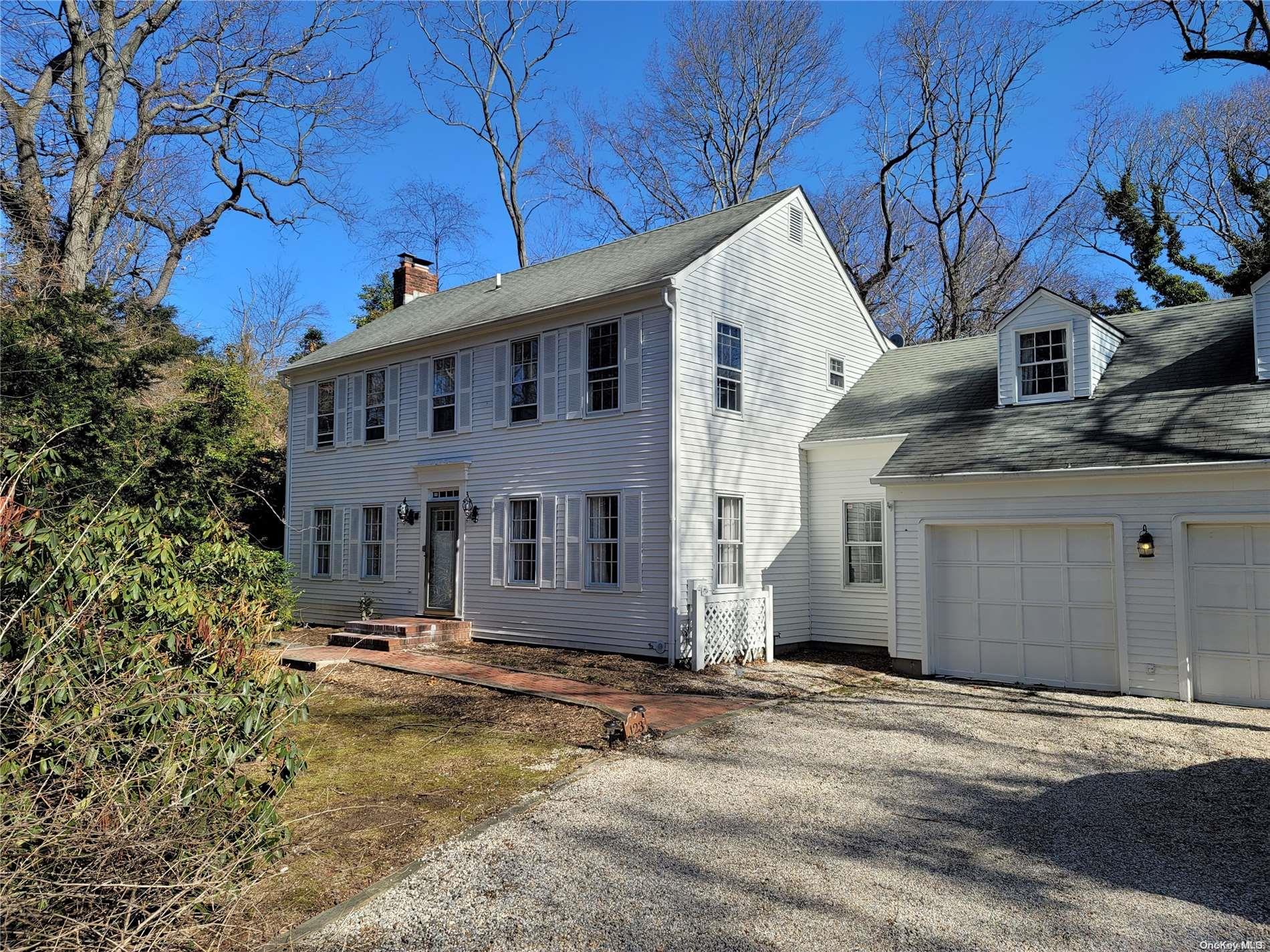 a view of a large white house with a large tree